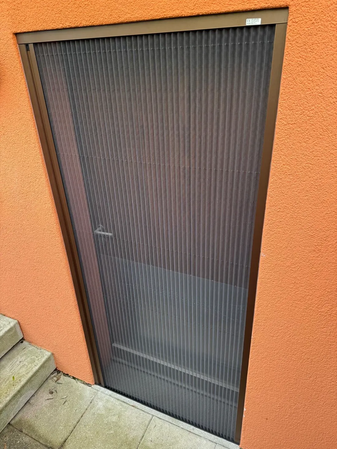 Zanzariera plissettata su una porta d'ingresso